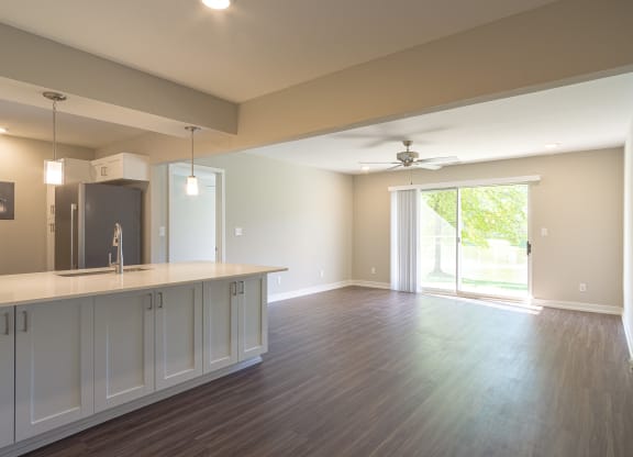 a kitchen and living room with a sliding glass door leading to a patio at Hillside Apartments, Michigan