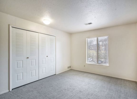 Bedroom with a large window and closet at Irish Hills Apartments, Indiana