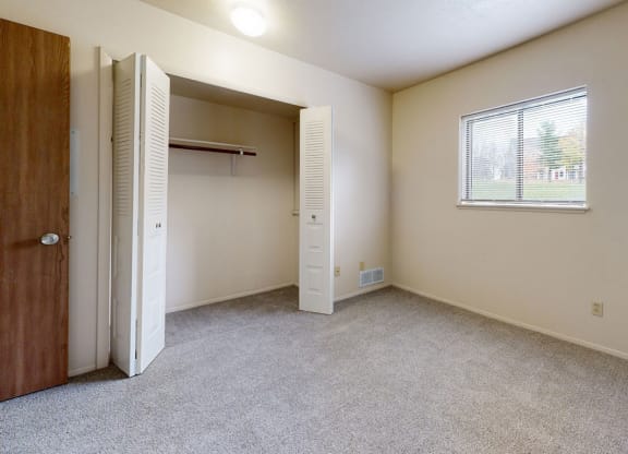 Bedroom with a large closet and a window at Irish Hills Apartments, South Bend