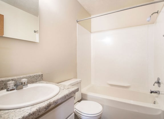 a renovated bathroom with a sink toilet and a bath tub at Irish Hills Apartments, South Bend