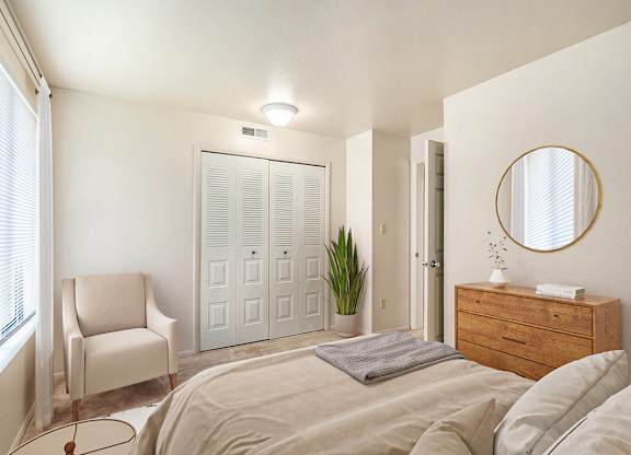 A bedroom with a bed, chair, a closet and a dresser at Irish Hills Apartments, South Bend, Indiana