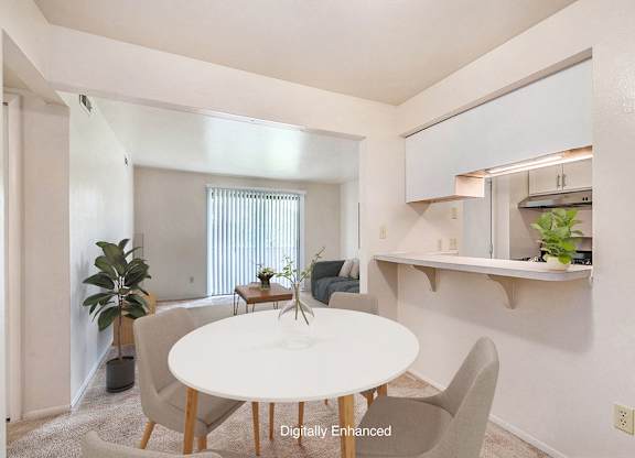 A dining room with a white table and chairs and a breakfast bar at Irish Hills Apartments, South Bend, Indiana