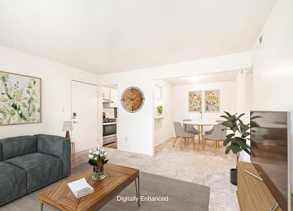 A living room with a couch and a dining room with a breakfast bar  and table with chairs at Irish Hills Apartments, South Bend, Indiana