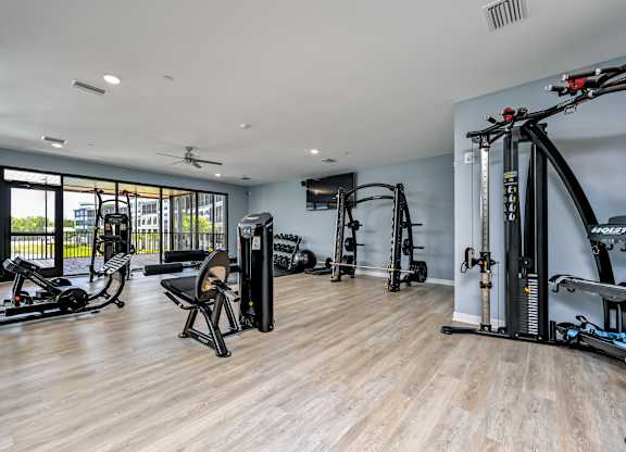 A spacious gym with a variety of equipment including a rowing machine, a stationary bike, and a treadmill at Ironwood Flats Apartments, Brandon, 33511