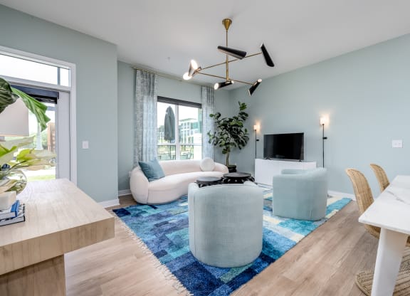 a living room with light blue walls and a blue rug at Ironwood Flats, Florida, 33511