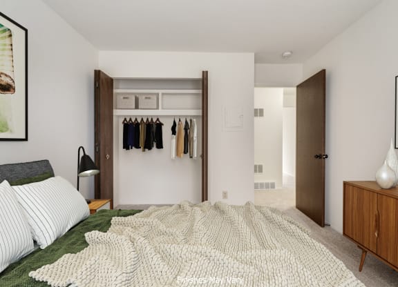 a bedroom with white walls and a large bed with a white blanket at The Landings Apartments, Westland, 48185
