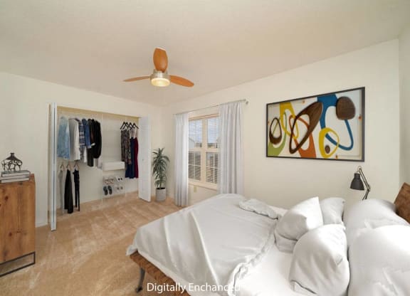 a bedroom with a bed, a ceiling fan and a closet with organizers at Limestone Creek Apartment Homes, Madison, AL