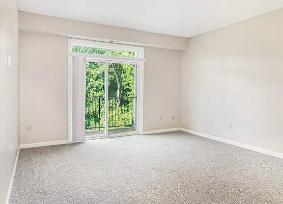 A living room with a carpeted floor and a 9 foot ceiling at Limestone Creek Apartment Homes, Madison, AL