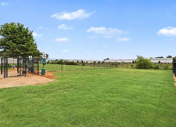 A pet park with a green lawn at Limestone Creek Apartment Homes, 35756