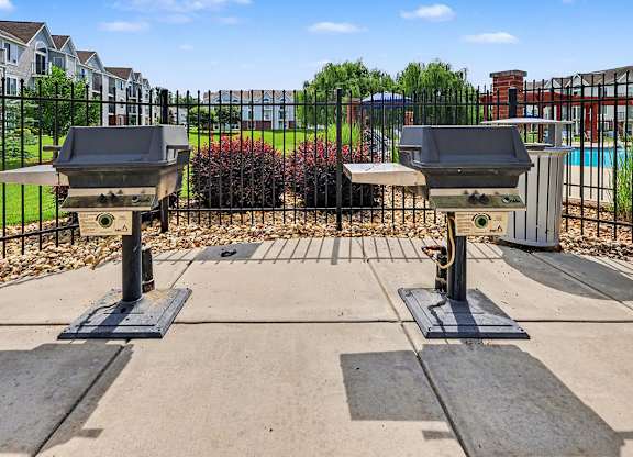Two grills are in the middle of a concrete patio at Limestone Creek Apartment Homes, 35756