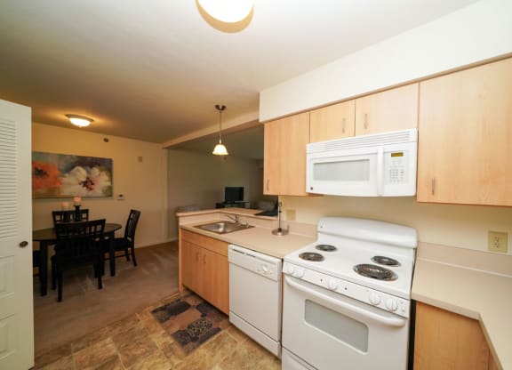 Maple Cabinetry and White Kitchen Appliances at Limestone Creek Apartment Homes, 35756
