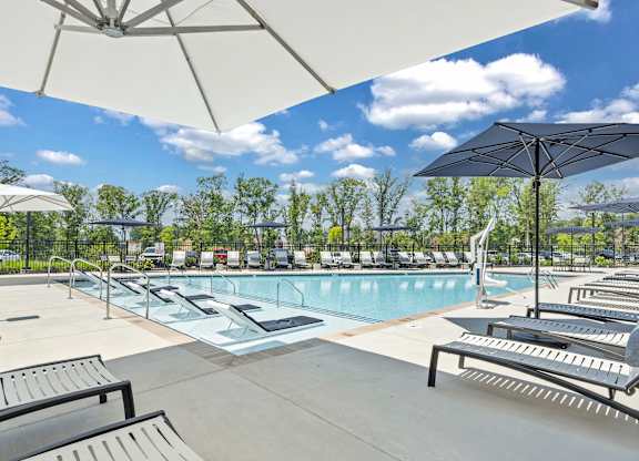 A sunny day at the pool with umbrellas and loungers at Luxe 360 on Centerpointe Apartments, Midlothian, 23114