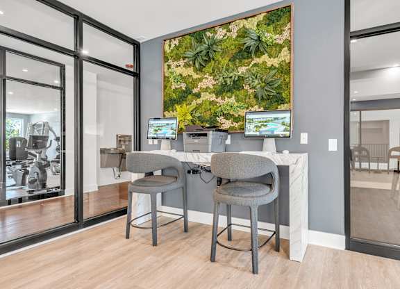 Two grey chairs are placed in front of a desk with a computer at Luxe 360 on Centerpointe Apartments, Midlothian, VA