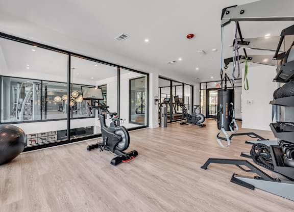 A gym with a variety of equipment including a stationary bike, a treadmill, and a rowing machine at Luxe 360 on Centerpointe Apartments, Midlothian
