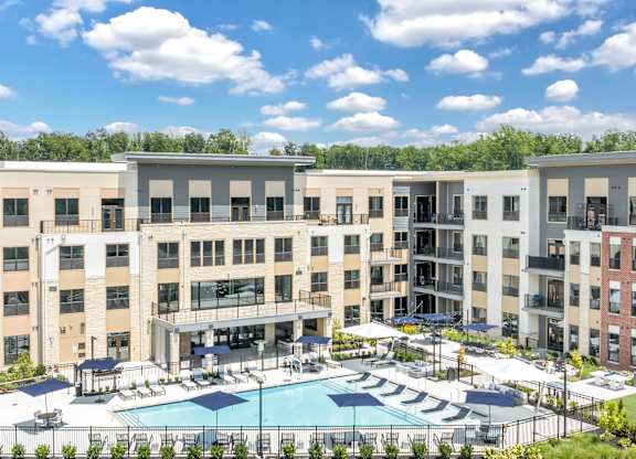 A large apartment complex with a pool in the middle at Luxe 360 on Centerpointe Apartments, Midlothian, VA