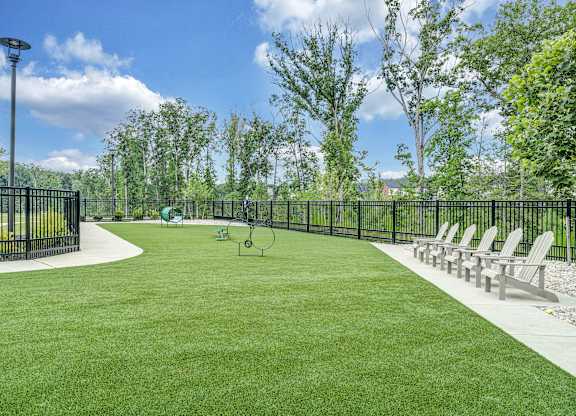 A park with a green lawn and a black fence