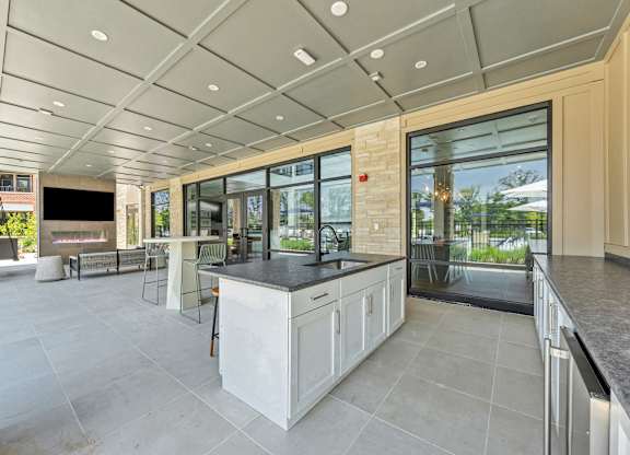 A modern kitchen with a large island and a view of the backyard at Luxe 360 on Centerpointe Apartments, Virginia, 23114