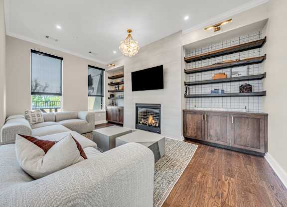A modern living room with a grey couch and a fireplace at Luxe 360 on Centerpointe Apartments, Midlothian, VA, 23114