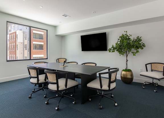 A conference room with a long table and chairs. at Luxe 360 on Centerpointe Apartments, Midlothian, VA