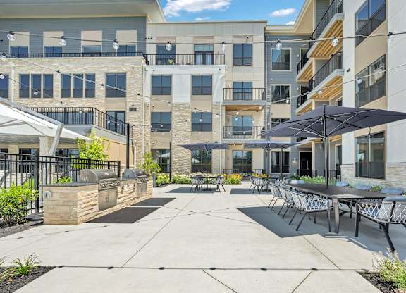 A sunny day at a modern apartment complex with a patio area at Luxe 360 on Centerpointe Apartments, Virginia