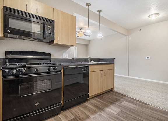 A kitchen with black appliances and hard surface flooring at Lynbrook Apartments and Townhomes, Elkhorn, NE, 68022