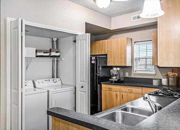 An end style kitchen with a washer and dryer at Lynbrook Apartments and Townhomes, Elkhorn, NE, 68022