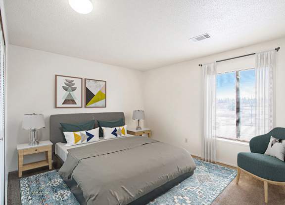 A bedroom with a bed, chair, and a window at Madeira Apartments in Kalamazoo, MI 49001
