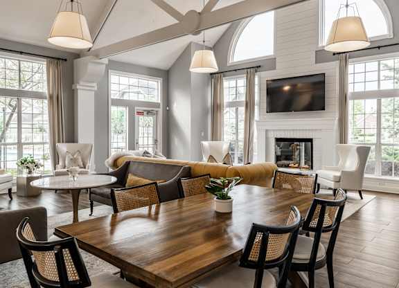 A large, well-lit living room with a wooden table and chairs at Mallard Bay Apartments, Crown Point, Indiana
