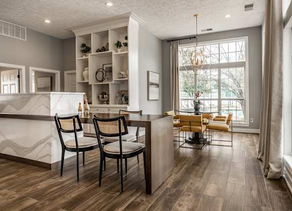A kitchen with a white counter and a dining table with chairs at Mallard Bay Apartments, Crown Point, Indiana