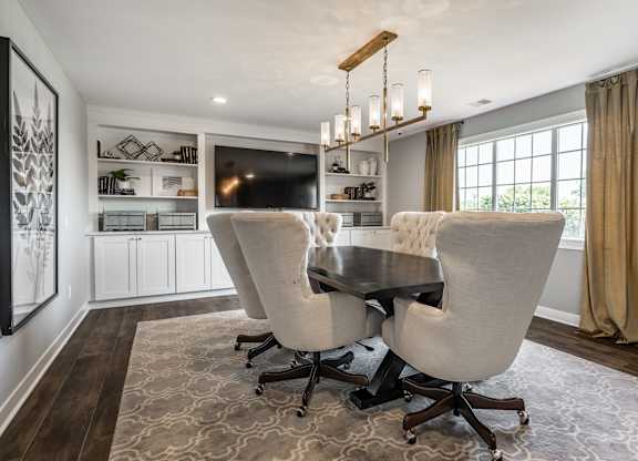 A large, well-lit living room with a wooden table and chairs at Mallard Bay Apartments, Crown Point, Indiana