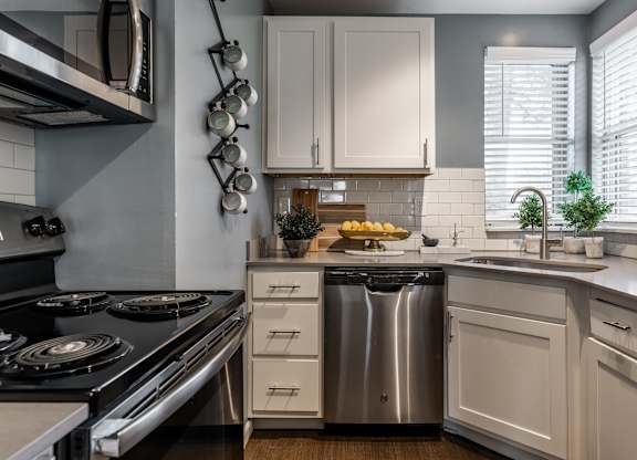 A modern kitchen with a stove, sink, and cabinets at Mallard Bay Apartments, Crown Point, Indiana