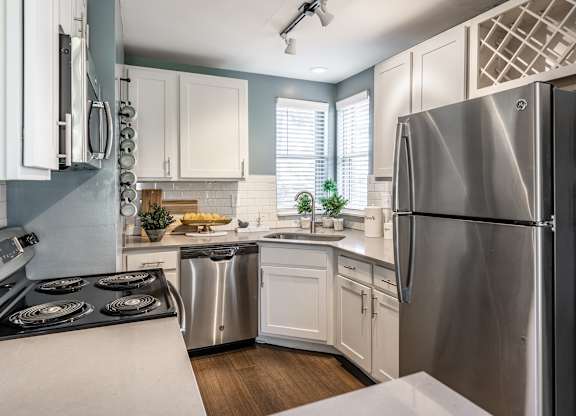 A modern kitchen with a stainless steel refrigerator and white cabinets at Mallard Bay Apartments, Crown Point, Indiana