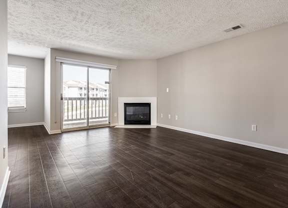 A spacious living room with a fireplace and sliding glass doors at Mallard Bay Apartments, Crown Point, Indiana