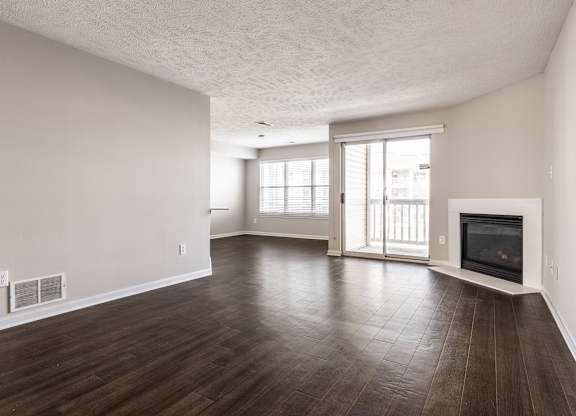 A spacious living room with wood flooring and a fireplace at Mallard Bay Apartments, Crown Point, Indiana