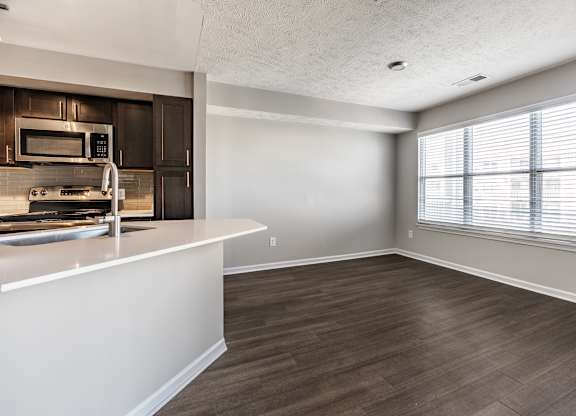 A kitchen with a white countertop and wooden flooring at Mallard Bay Apartments, Crown Point, Indiana
