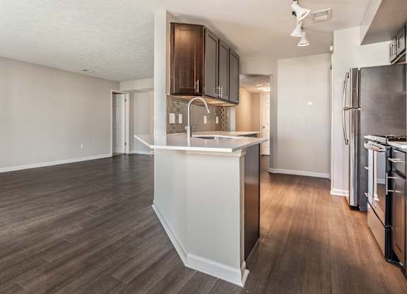 A kitchen with a refrigerator, sink, and cabinets at Mallard Bay Apartments, Crown Point, Indiana
