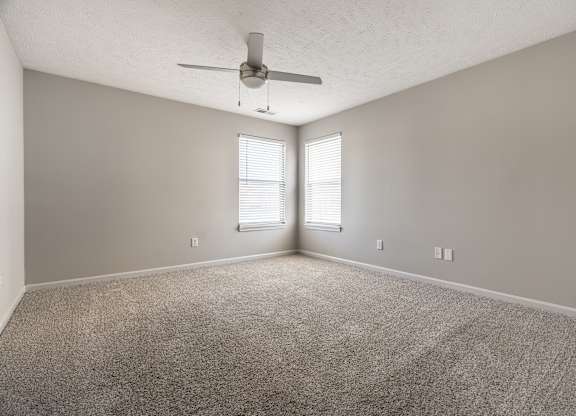 A room with a ceiling fan and carpeted floor at Mallard Bay Apartments, Crown Point, Indiana