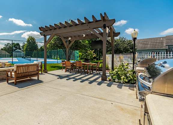 A sunny day at the poolside with a wooden pergola and lounge chairs at Mallard Bay Apartments, Crown Point, Indiana