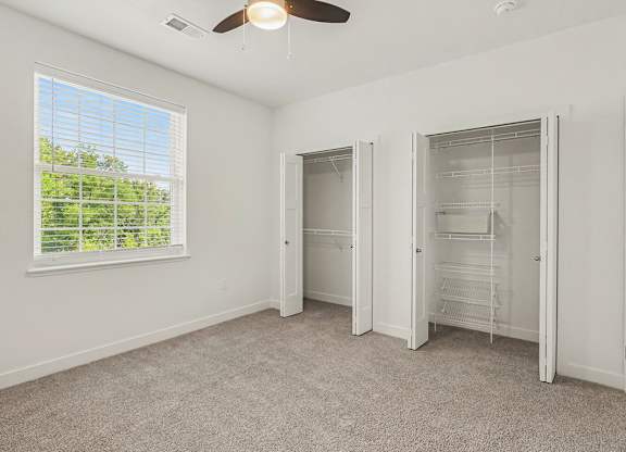 A bedroom with a ceiling fan and a window with blinds at Meadowbrooke Apartment Homes in Grand Rapids, MI 49512