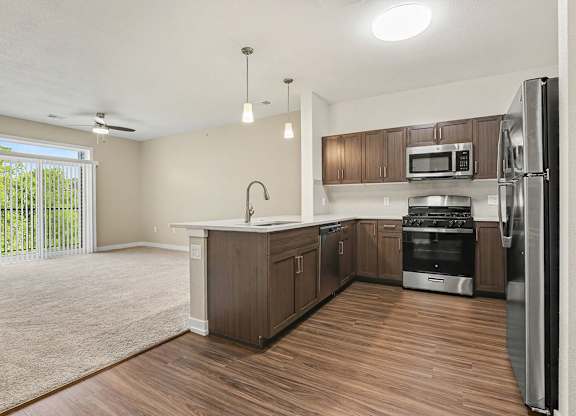 A kitchen with hard-surface floors and stainless steel appliances at Meadowbrooke Apartment Homes in Grand Rapids, MI 49512