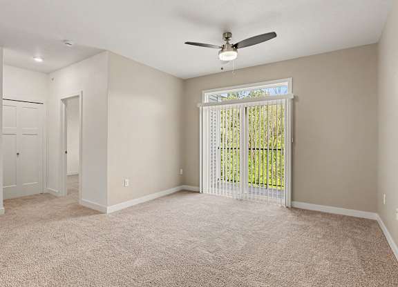 A living room with a ceiling fan and carpeted floor at Meadowbrooke Apartment Homes in Grand Rapids, MI 49512