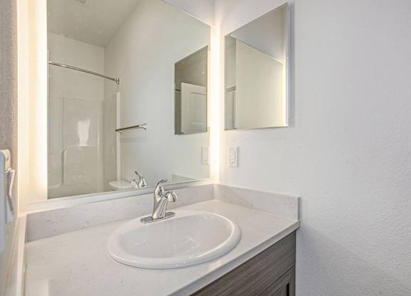 A bathroom with a white sink and a mirror above it at Meadowbrooke Apartment Homes in Kentwood, MI 49512