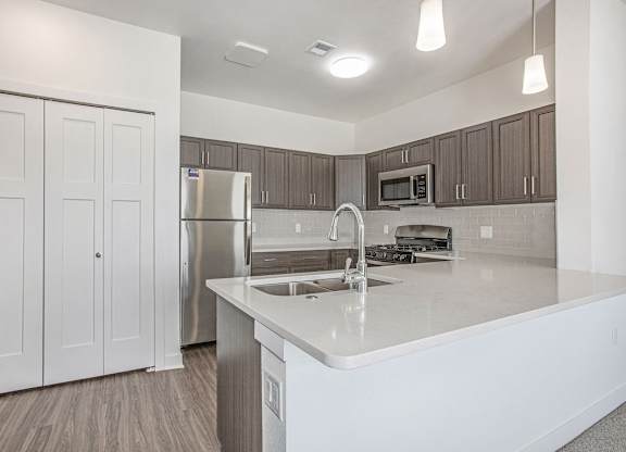 A kitchen with a breakfast bar at Meadowbrooke Apartment Homes in Kentwood, MI 49512