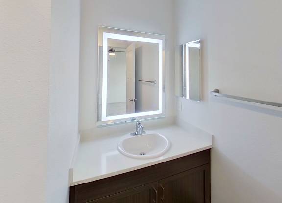A bathroom with a sink and mirror at Meadowbrooke Apartment Homes in Kentwood, MI 49512