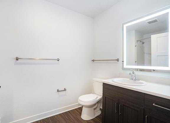 A bathroom with a sink, toilet and a mirror at Meadowbrooke Apartment Homes in Kentwood, MI 49512