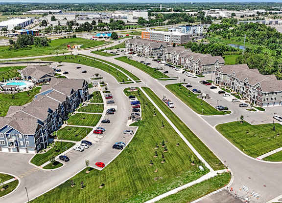 A large grassy area with a road and apartment buildings at Meadowbrooke Apartment Homes in Grand Rapids, MI 49512