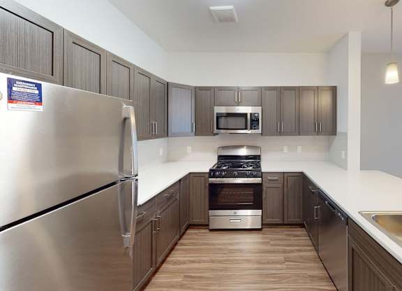A modern kitchen with stainless steel appliances and a breakfast bar at Meadowbrooke Apartment Homes in Kentwood, MI 49512