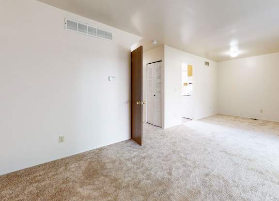 A living and dining room with a carpeted floor at Mount Royal Townhomes, Kalamazoo, MI