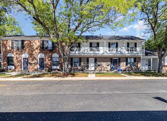 A townhome building with trees in front at Mount Royal Townhomes in Kalamazoo, MI