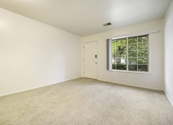 Main floor living with a large window at Newport Village Apartments, Portage, MI